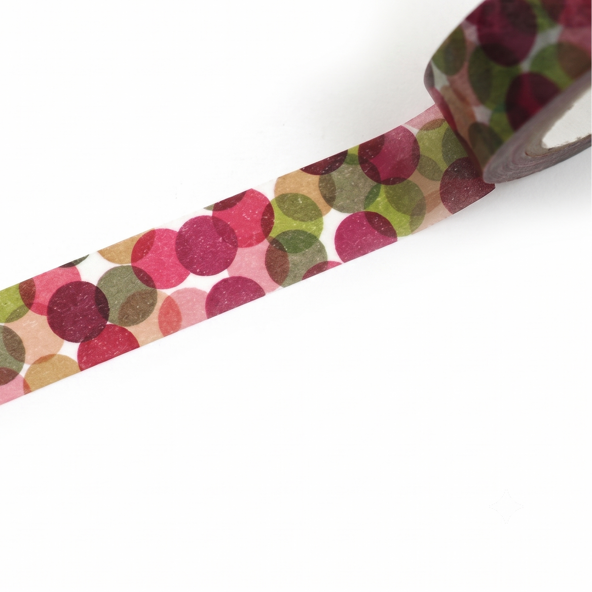 A close-up of a roll of washi tape with a pattern of overlapping polka dots in pink, burgundy, olive green, and beige on a white background.