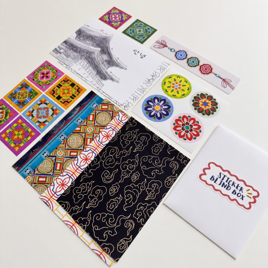 A sticker blind box set displayed on a white background, featuring patterned sticker sheets, floral sticker designs, a black patterned sheet, and a white envelope labeled 'STICKER BLIND BOX'.