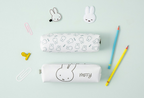 Two white pencil cases with black bunny illustration lineworks of Miffy. They are arranged on a pale mint background with stationery props including paper clips, pencils, and bunny-shaped accessories.