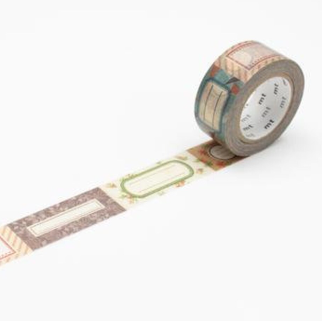 A roll of decorative washi tape with a vintage label pattern, shown partially unrolled on a clean white background.